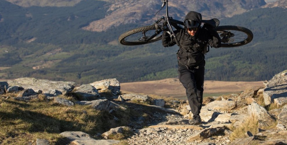 mountain bike rider carrying bike on Snowdon mountain